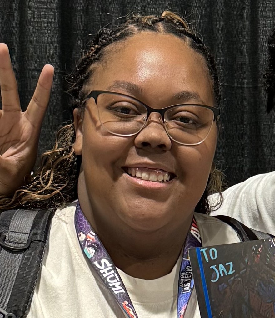 Jasmine smiling and throwing a peace sign at an anime convention