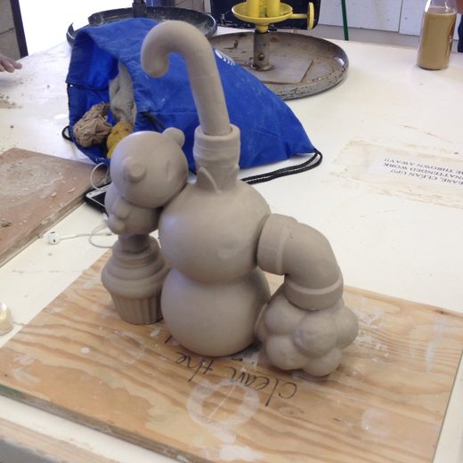 Unfired clay sculpture of a playful character built from spheres and pipes